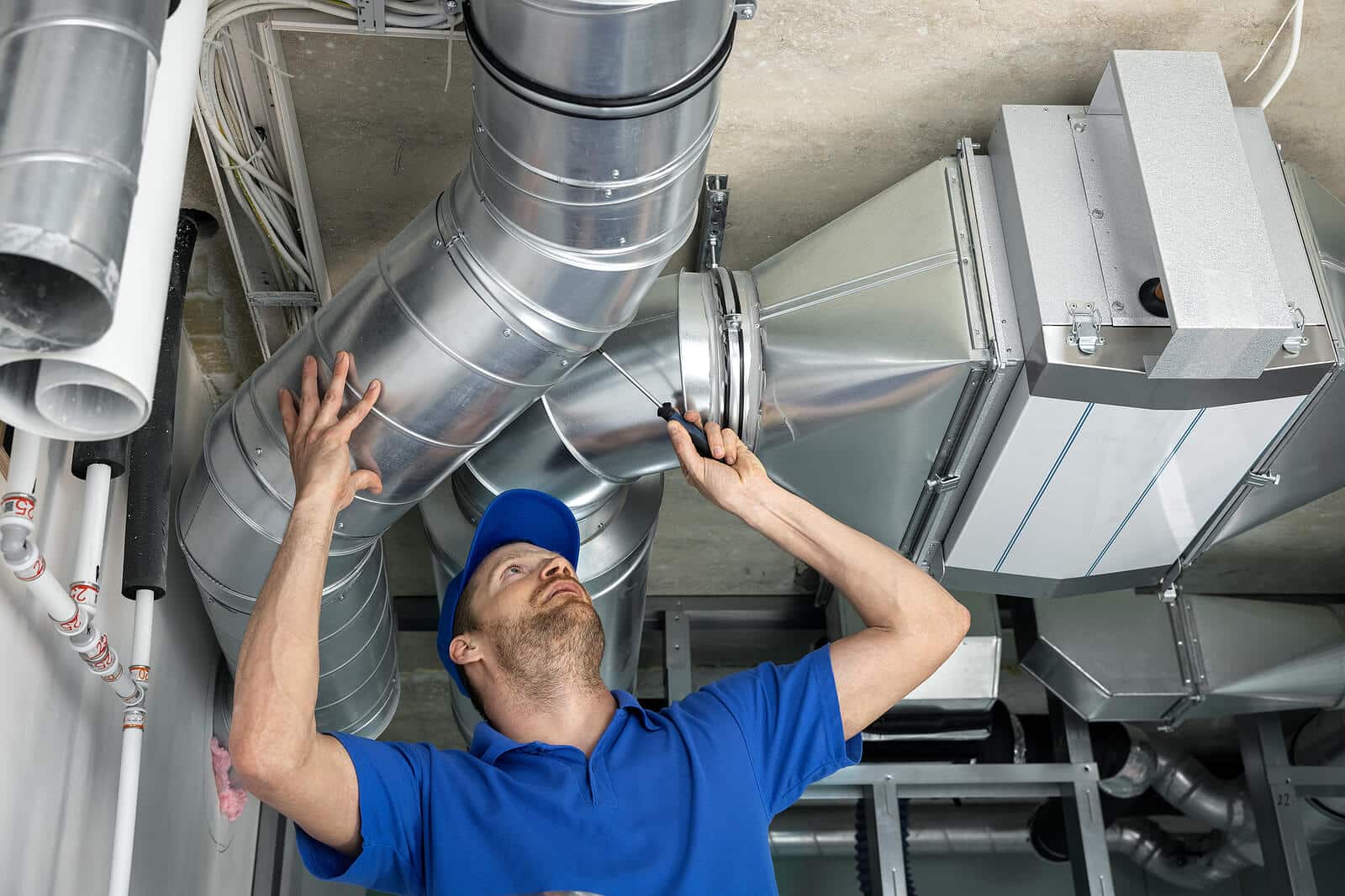 HVAC technician inspecting and repairing air ducts in West Sacramento