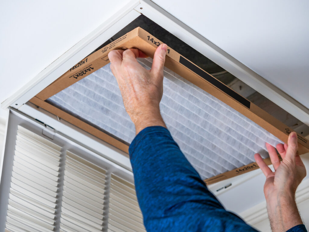 HVAC technician replacing a home air filter in West Sacramento