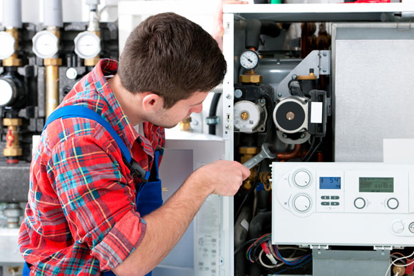 Heating technician repairing boiler controls in West Sacramento