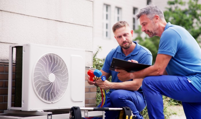 HVAC technicians installing an outdoor air conditioning unit in West Sacramento